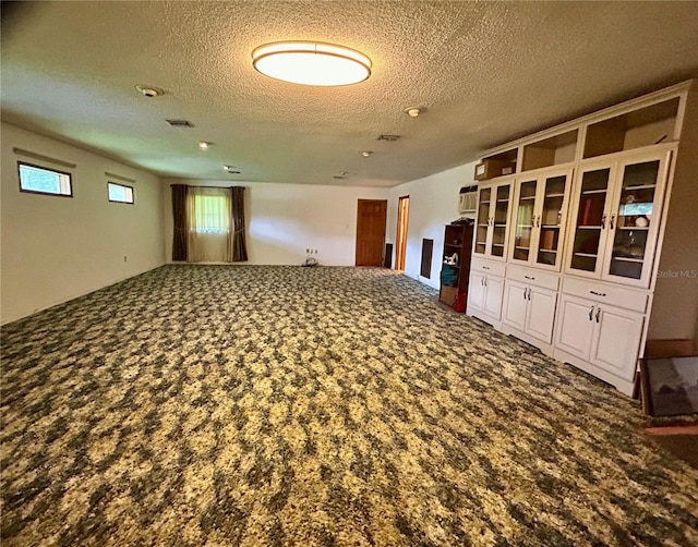 empty room with carpet floors and a textured ceiling