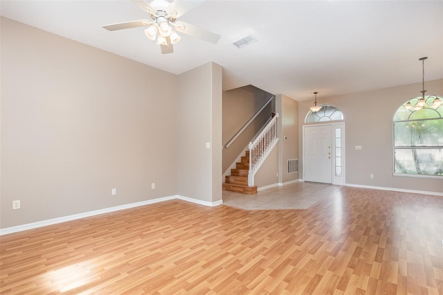 interior space featuring light wood-type flooring and ceiling fan with notable chandelier