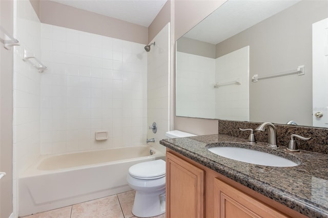 full bathroom with tile patterned flooring, tiled shower / bath, vanity, and toilet