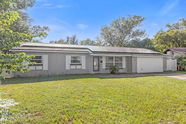 single story home featuring solar panels, a front lawn, and a garage