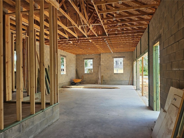 misc room with plenty of natural light, concrete floors, and brick wall