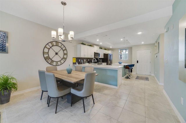 tiled dining space with an inviting chandelier and sink