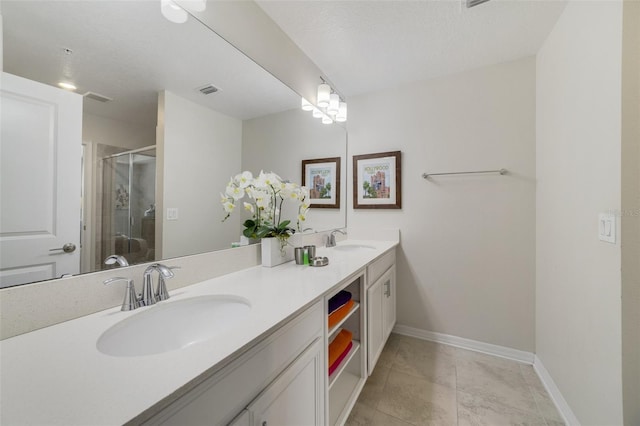 bathroom with tile patterned floors, an enclosed shower, vanity, and a textured ceiling