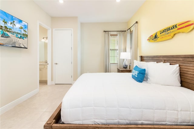 bedroom with light tile patterned floors and ensuite bathroom