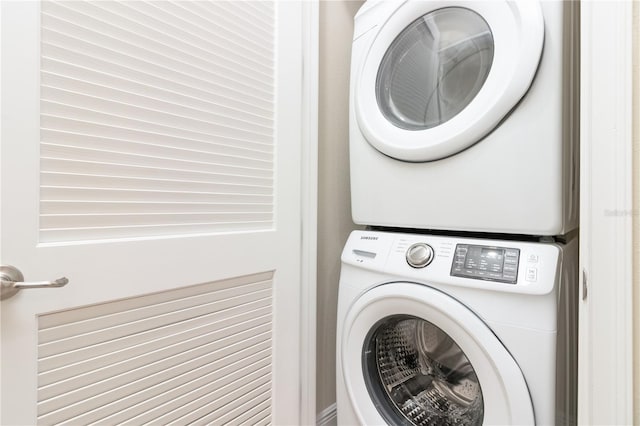 clothes washing area with stacked washer / dryer