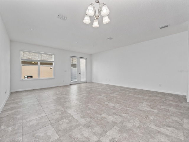 spare room with a notable chandelier