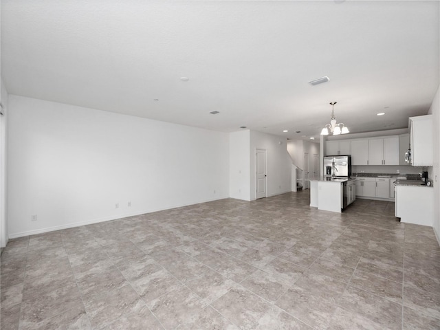 unfurnished living room with an inviting chandelier