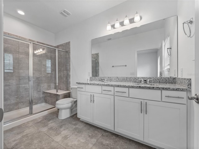 bathroom with tile patterned flooring, walk in shower, vanity, and toilet