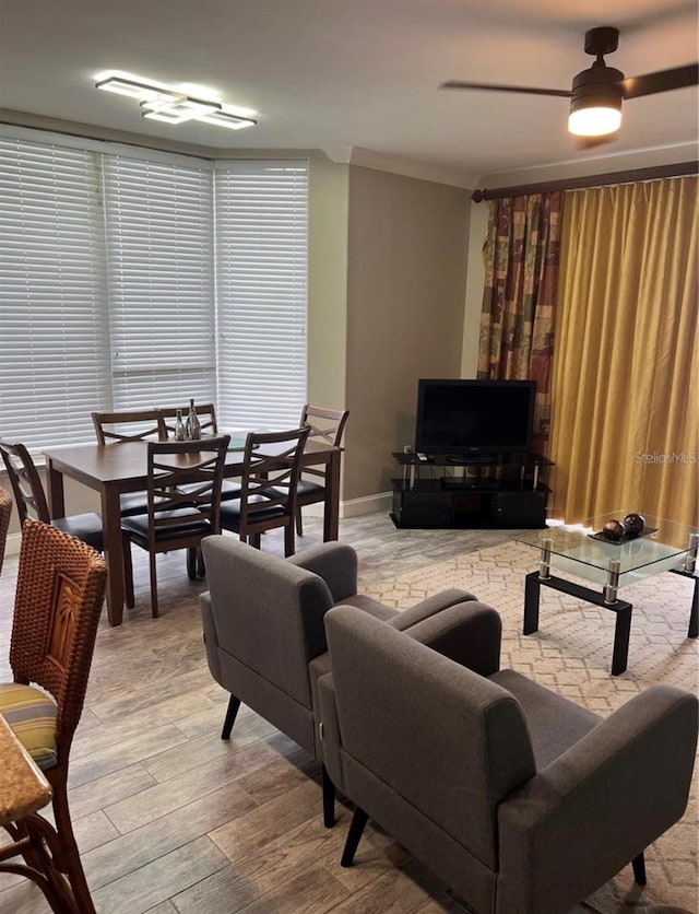 living room featuring light wood-type flooring, ornamental molding, and ceiling fan