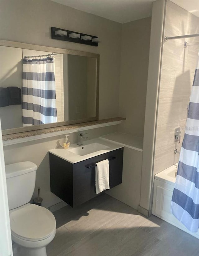 full bathroom featuring shower / tub combo with curtain, vanity, and toilet