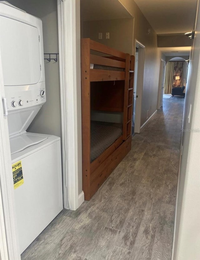 washroom with stacked washer / drying machine and hardwood / wood-style floors