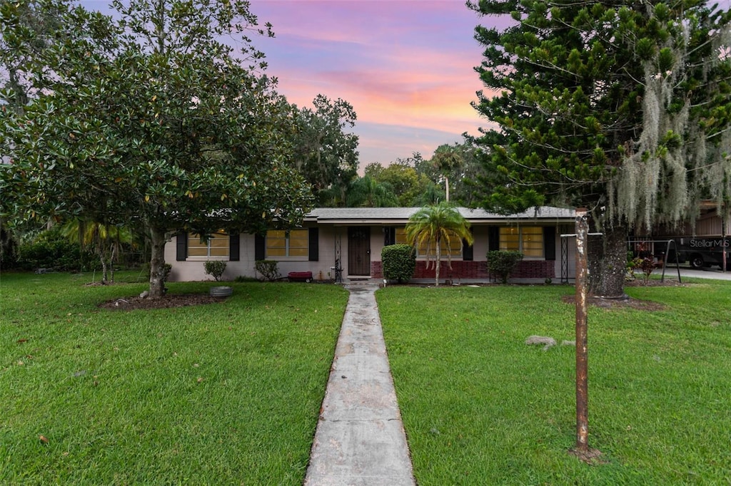 ranch-style home with a yard