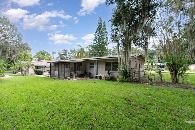 back of property featuring a lawn and central air condition unit