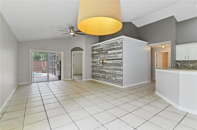 spare room with high vaulted ceiling, ceiling fan, and light tile patterned floors