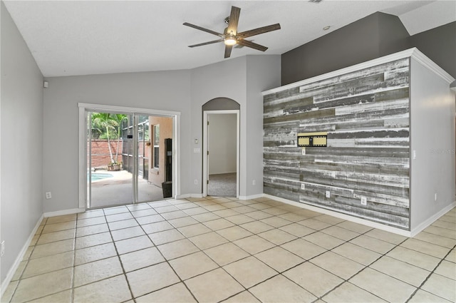 spare room featuring light tile patterned floors, lofted ceiling, and ceiling fan