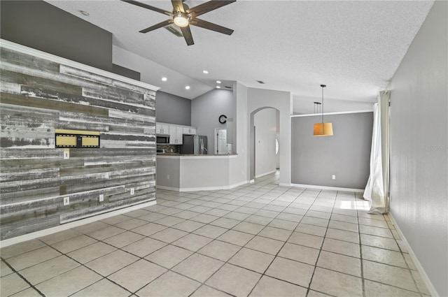 interior space featuring ceiling fan, a textured ceiling, and lofted ceiling