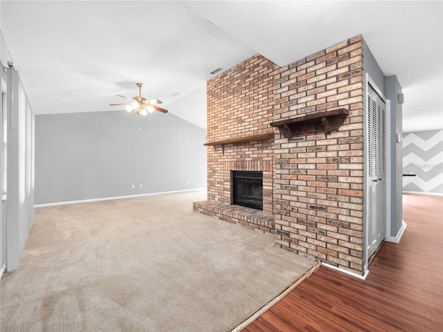 unfurnished living room featuring a fireplace, vaulted ceiling, ceiling fan, and hardwood / wood-style flooring