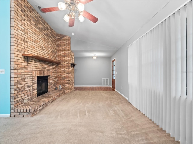 unfurnished living room with lofted ceiling, a fireplace, ceiling fan, and light colored carpet