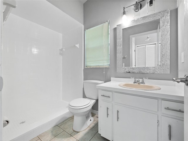 bathroom featuring vanity, a shower, toilet, and tile patterned floors