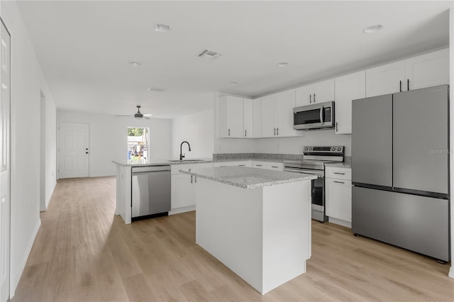 kitchen featuring ceiling fan, kitchen peninsula, light hardwood / wood-style flooring, white cabinetry, and stainless steel appliances