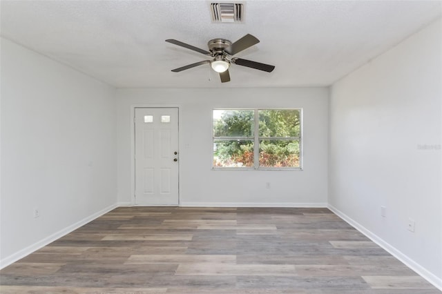 foyer featuring ceiling fan, a textured ceiling, and light wood-type flooring