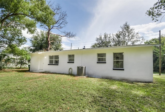 rear view of house with a lawn and central air condition unit