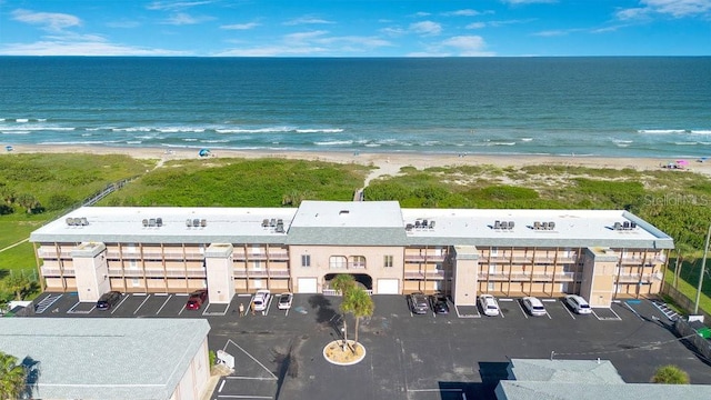 birds eye view of property featuring a water view and a beach view