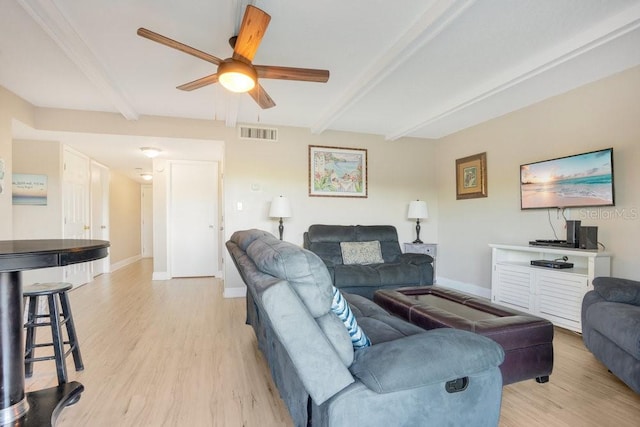 living room with light hardwood / wood-style flooring, ceiling fan, and beamed ceiling