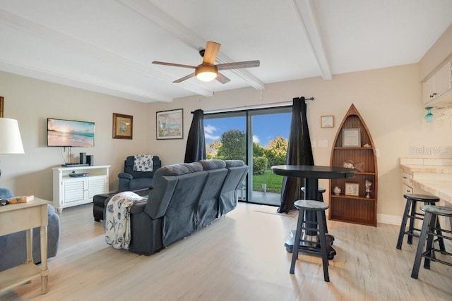 living room featuring light hardwood / wood-style flooring, ceiling fan, and beamed ceiling