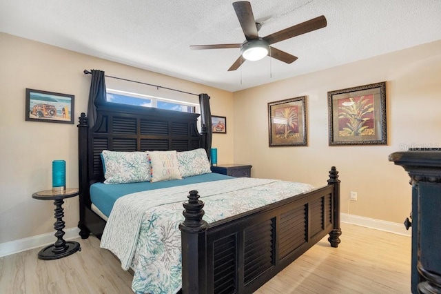 bedroom with light hardwood / wood-style floors, ceiling fan, and a textured ceiling