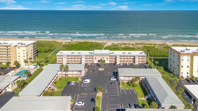 drone / aerial view featuring a water view and a beach view