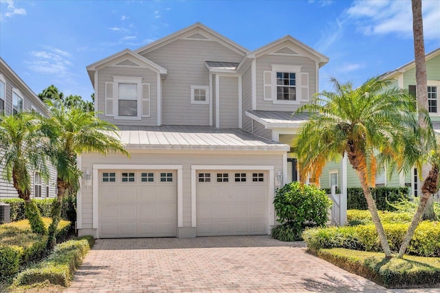 view of front of property featuring a garage and central air condition unit