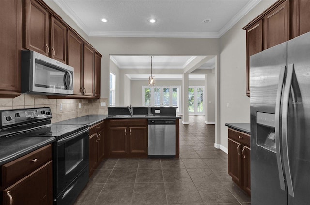 kitchen with appliances with stainless steel finishes, hanging light fixtures, backsplash, and crown molding