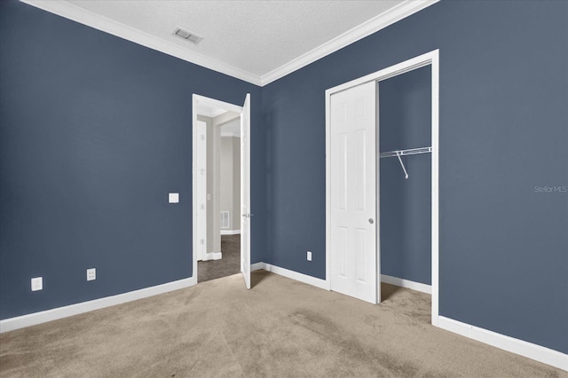 unfurnished bedroom with a textured ceiling, crown molding, light carpet, and a closet