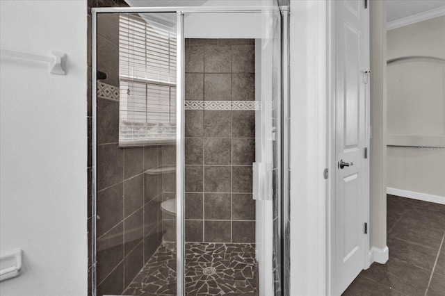 bathroom featuring crown molding, tile patterned flooring, and a shower with door