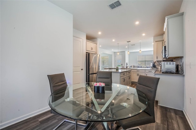 dining space with dark hardwood / wood-style floors and sink