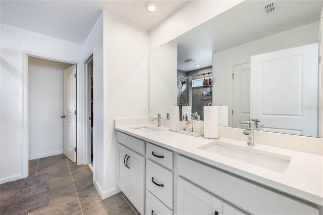 bathroom with a tile shower and vanity