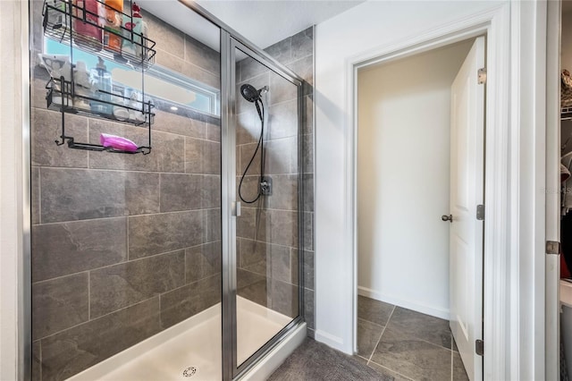 bathroom featuring tile patterned floors and a shower with shower door