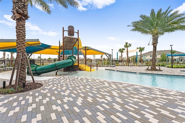 view of swimming pool featuring a playground and a water slide