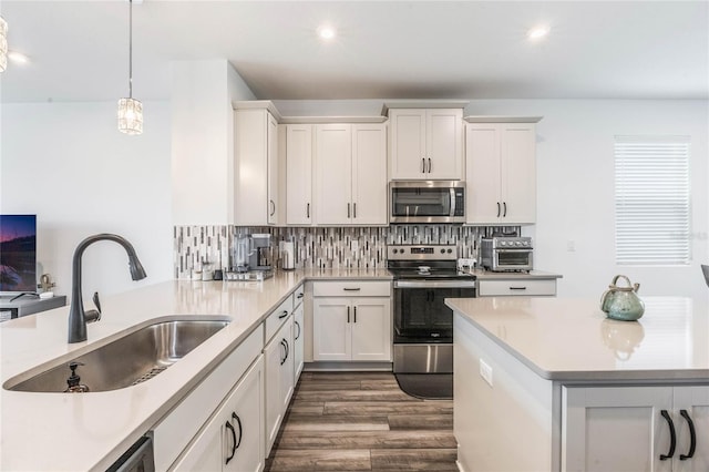 kitchen featuring pendant lighting, sink, white cabinetry, and stainless steel appliances