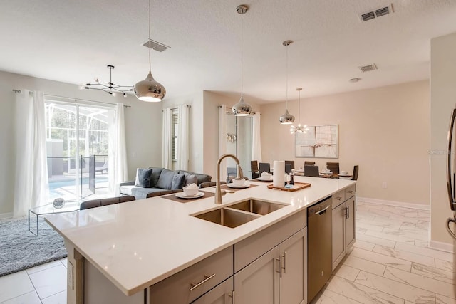 kitchen with pendant lighting, dishwasher, sink, an island with sink, and a textured ceiling