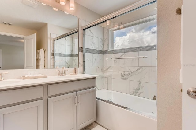 bathroom featuring vanity and bath / shower combo with glass door