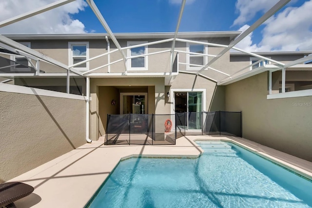 back of property featuring glass enclosure and a patio