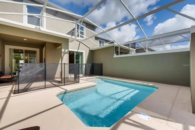 view of pool featuring glass enclosure and a patio