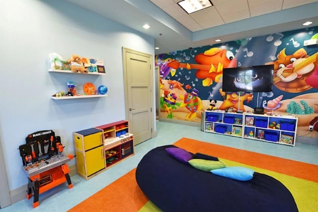 playroom with a raised ceiling