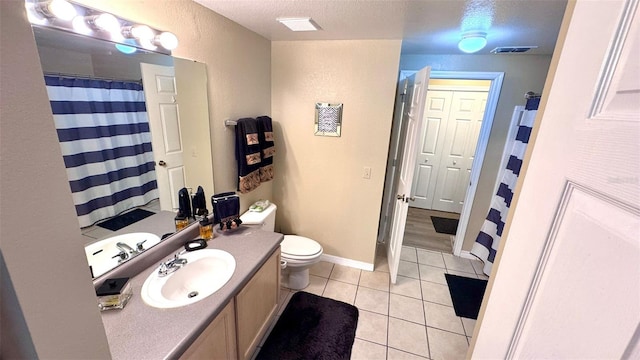 bathroom with vanity, a textured ceiling, toilet, and tile patterned floors