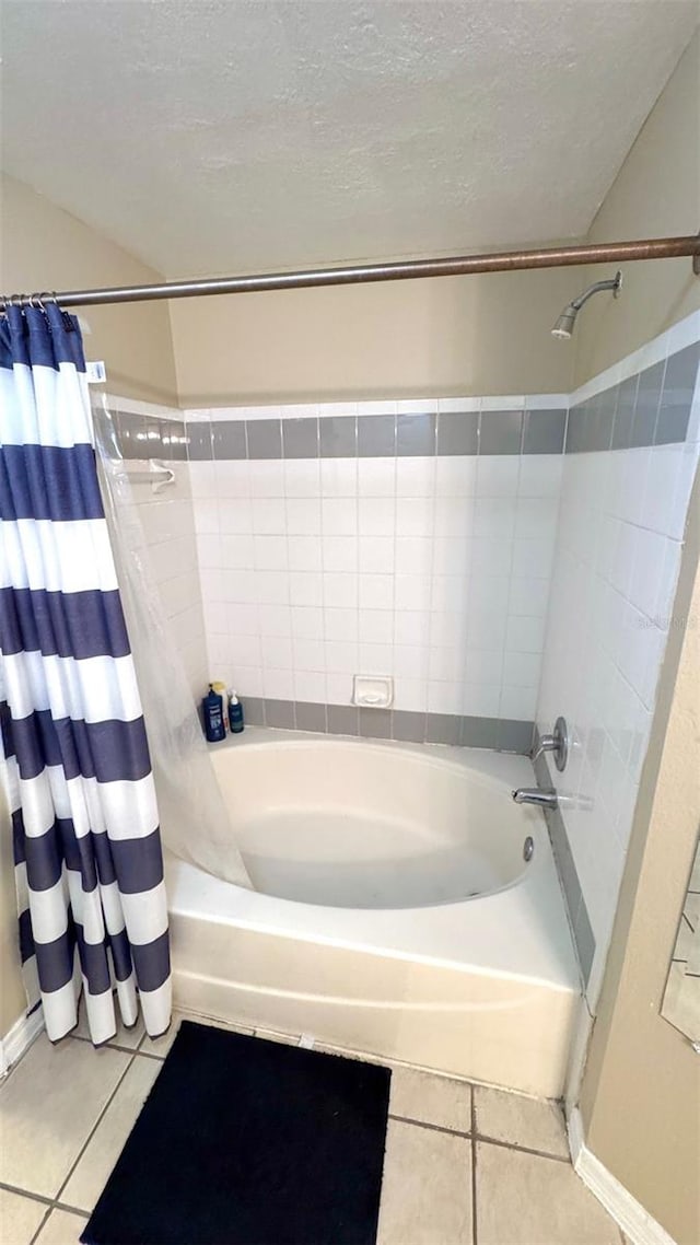 bathroom with tile patterned floors, shower / bath combination with curtain, and a textured ceiling