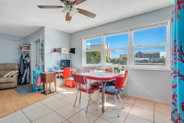 dining space with a healthy amount of sunlight, baseboards, ceiling fan, and tile patterned floors