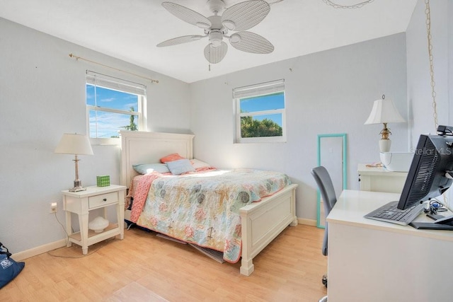 bedroom featuring baseboards, a ceiling fan, and light wood finished floors