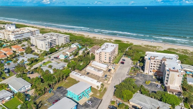 birds eye view of property with a water view and a beach view